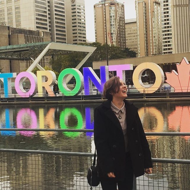 Student standing in front of Toronto sign