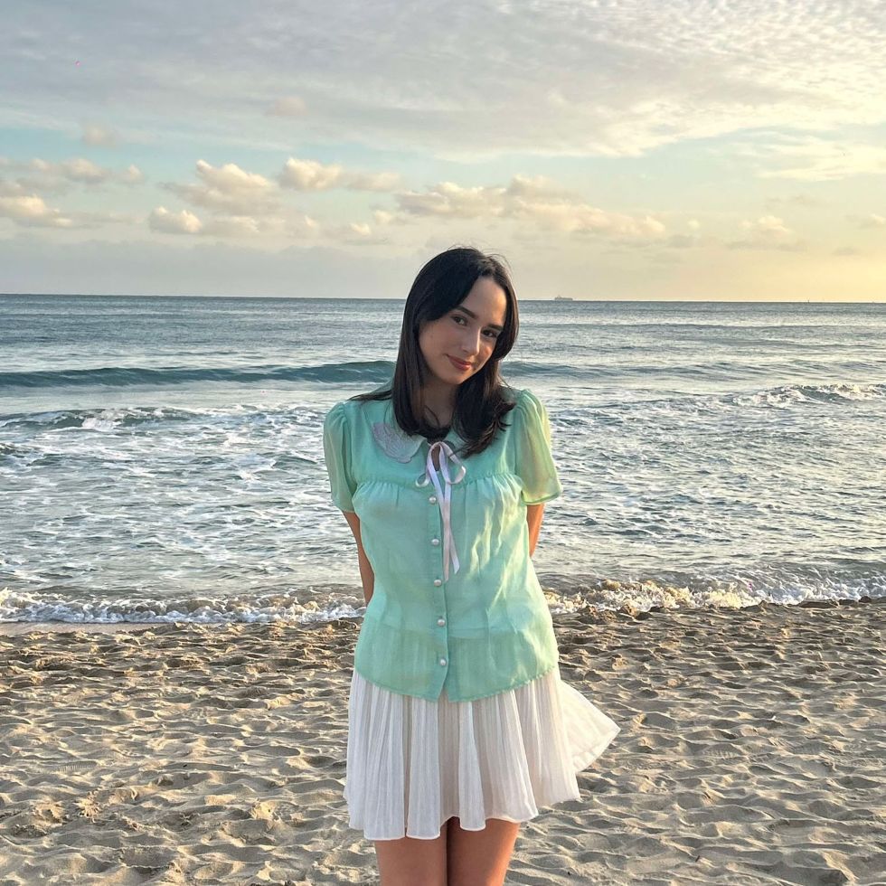 Laura in Busan in front of the beach on a sunny day.