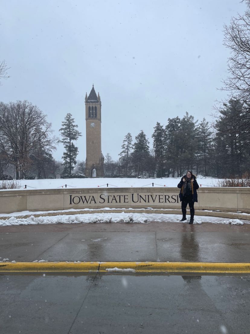 student standing in front of Iowa sign