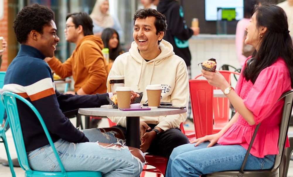 Students sitting around a table laughing