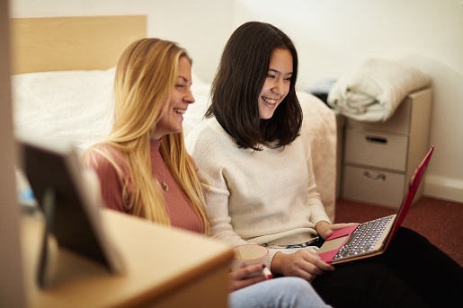 Two students on laptop in student accommodation.