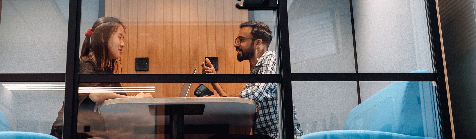 Two international students sitting in study pods on the campus. 