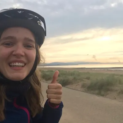 Image of student riding a bike by Swansea sea front.