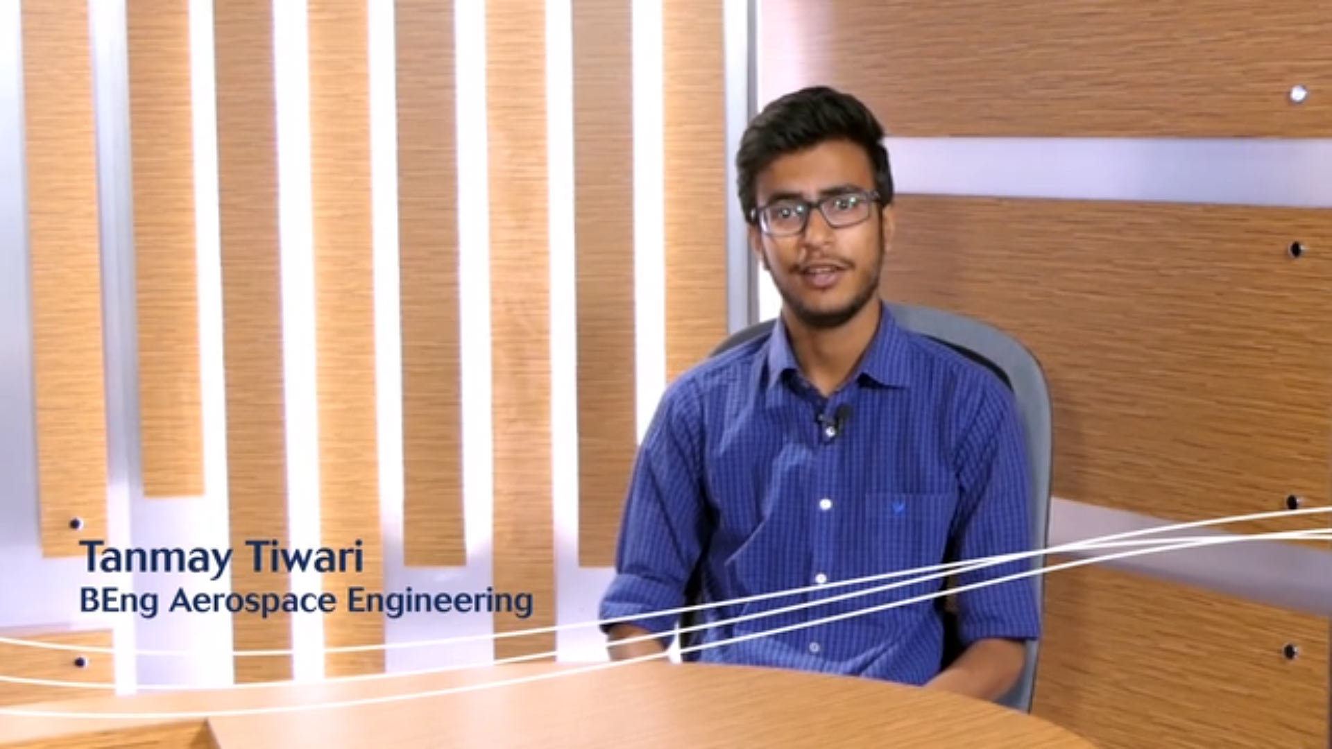 Indian student Tanmay sitting in a studio looking at the camera.