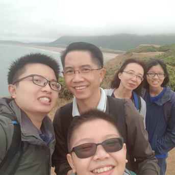 Smiling family from Thailand on the coast of Gower