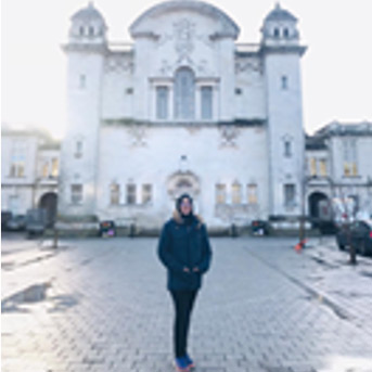 Student standing in front of a white building