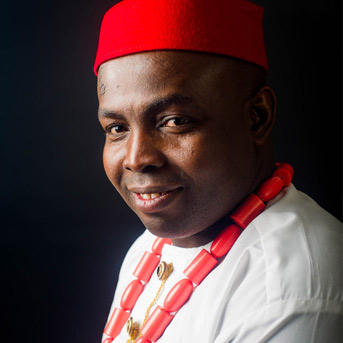 Male student from Nigeria smiling at camera wearing a Fez hat