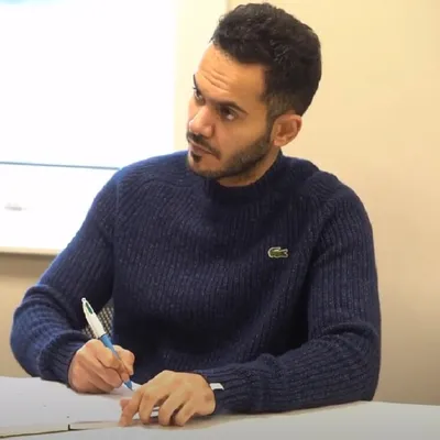 Image of Mohammed writing at a desk.