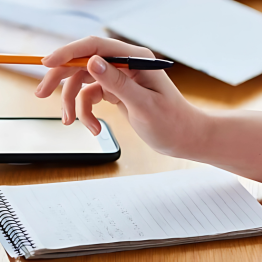 A hand holding a pen, writing notes