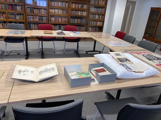 Books and other collection materials on a wooden table in the reading room