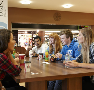 Two students walking out of root - food store on Singleton Campus.