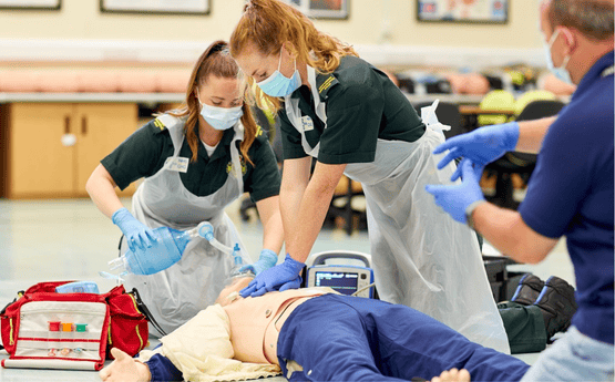 Paramedic students assessing a dummy. 