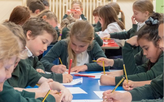 Children writing around table