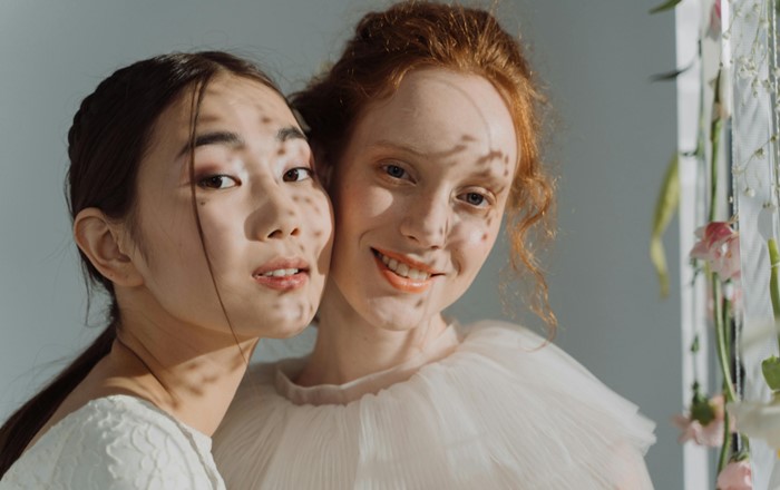 An Asian woman and Caucasian woman stood side by side 