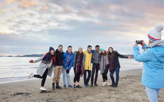 Students taking a photograph on the beach. 