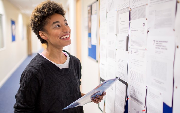 A student looking at a bulletin board.