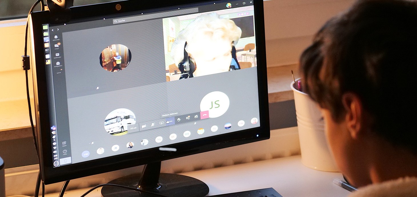 Child sitting at a desk looking at a computer.