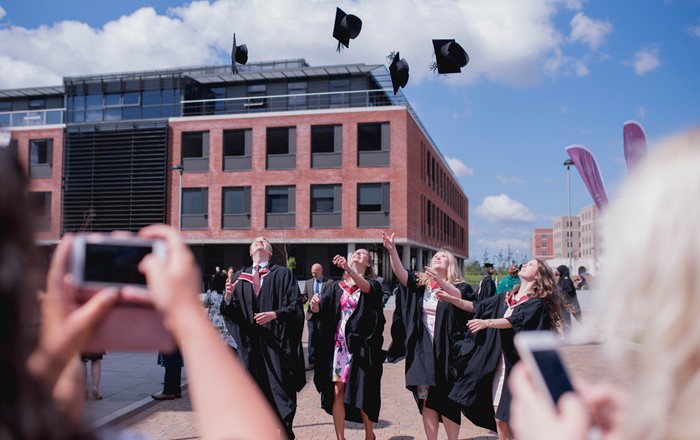 A group of students throwing their graduation caps in the air.