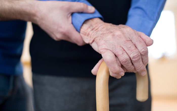 An elderly man's hand on a walking stick 