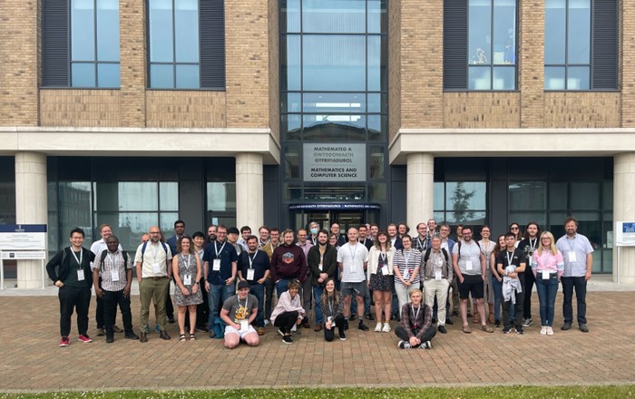 Group of people lined up for a photography standing outside a building