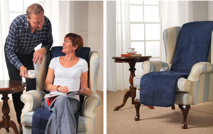 Man bringing a cup of tea to a woman sitting in an armchair and an armchair with an electric seat cover draped over the back and seat