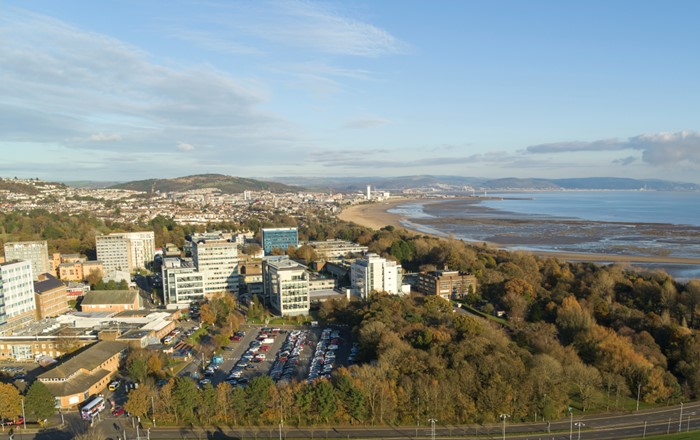 Aerial view of Swansea city and bay with Swansea University in the foreground.