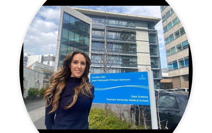 Woman standing in front of a sign outside a modern building