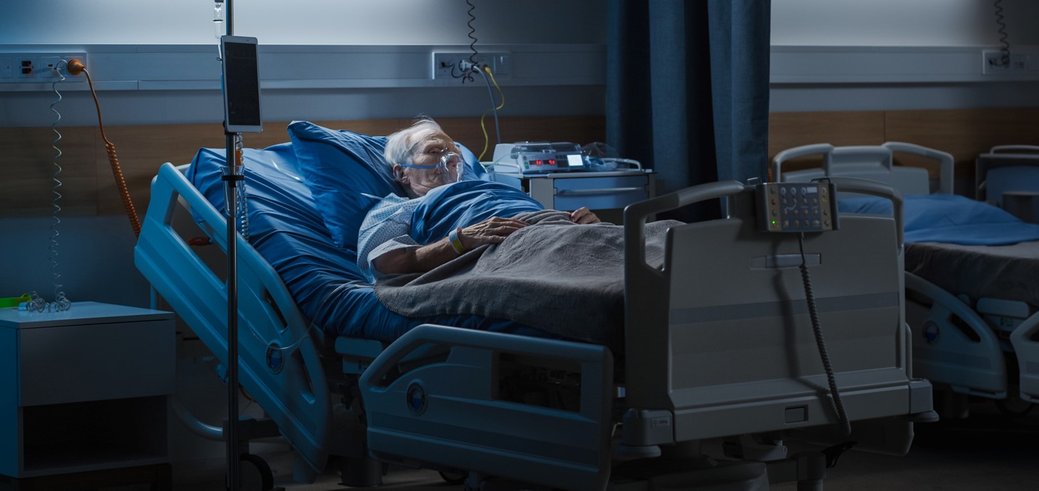 Elderly male patient lying in a hospital bed