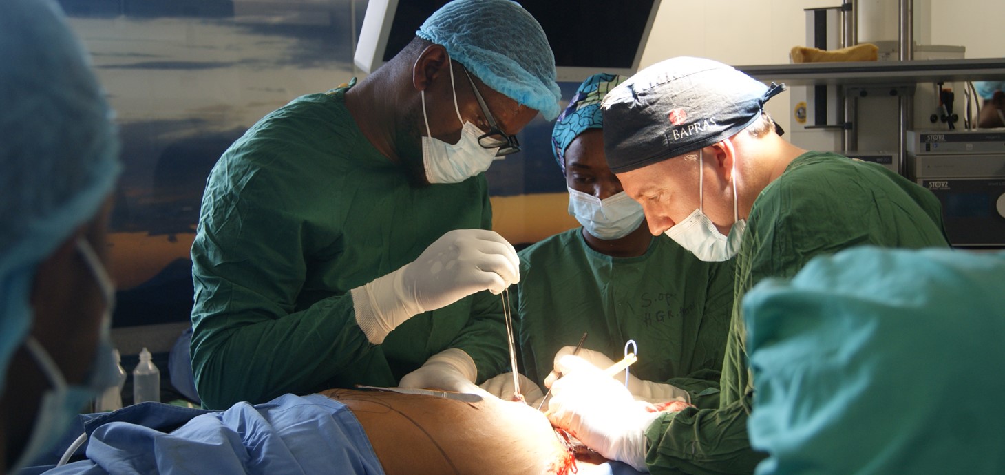 Two surgeons wearing medical scrubs carrying out an operation.