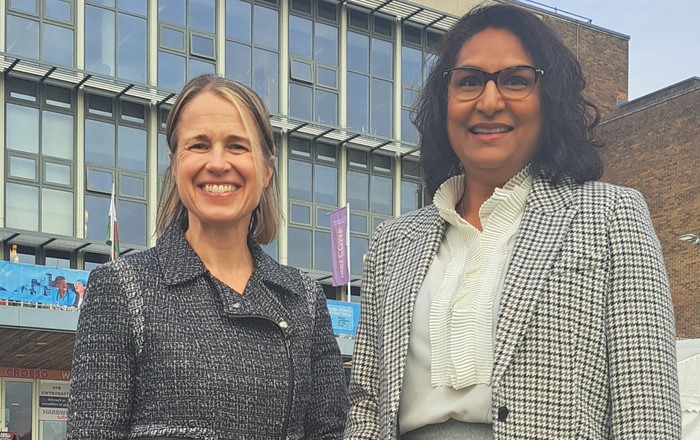 Two women standing in front of a building.