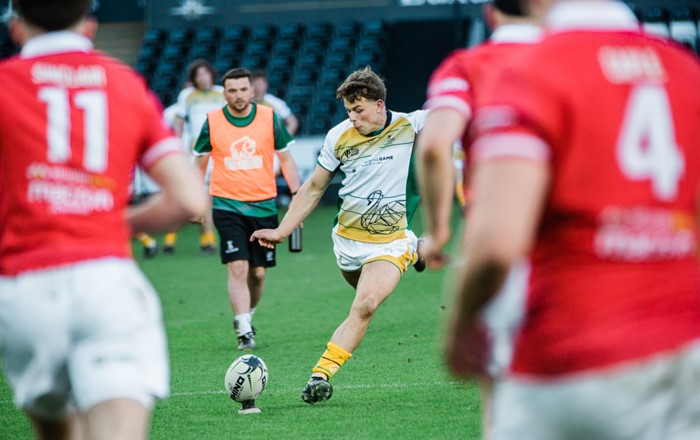 A Swansea rugby player kicking a ball