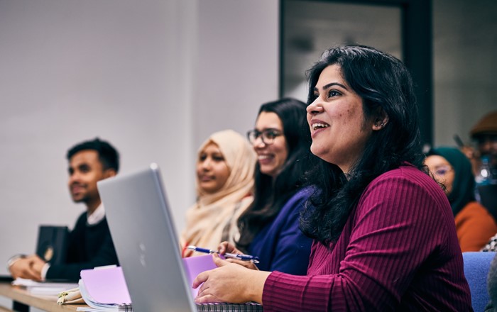 Students with laptops at a lecture.