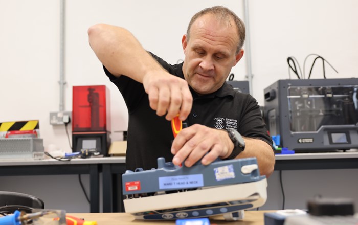 Man using screwdriver to repair machine