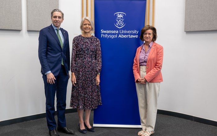 The Tánaiste Simon Harris TD, Professor Helen Griffiths and First Minister of Wales Eluned Morgan MS, at Swansea University. They are pictured standing in front of a Swansea University banner.