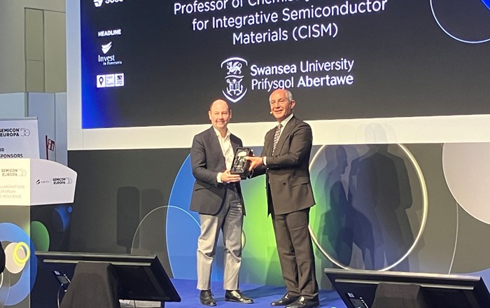 A photo of Professor Guy on stage at the CxO Executive Summit to accept the SEMI Academia Impact Award.