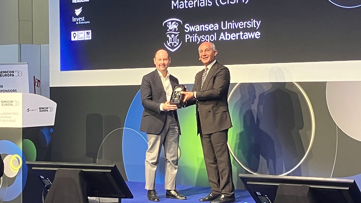 A photo of Professor Guy on stage at the CxO Executive Summit to accept the SEMI Academia Impact Award.