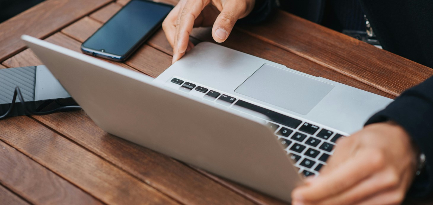 Close up of man's hands with a laptop on a table