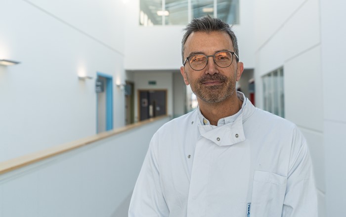 Man in lab coat standing in corridor