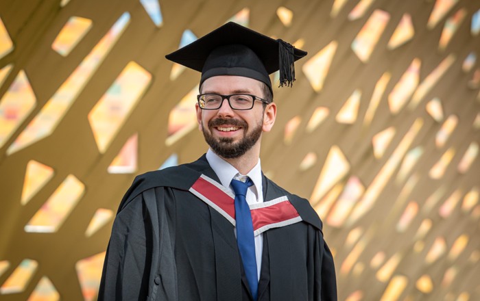 A photo of Jon in his cap and gown at graduation.