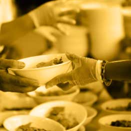 A lady serving food to a gentleman over a counter