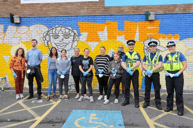 Group of community in front of art wall