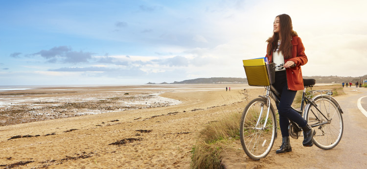 student with bike on the beach