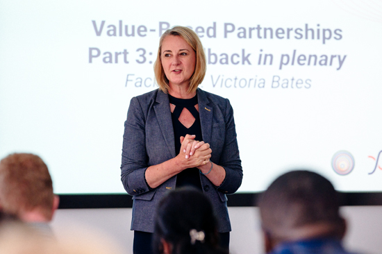 A woman presenting in front a room of people