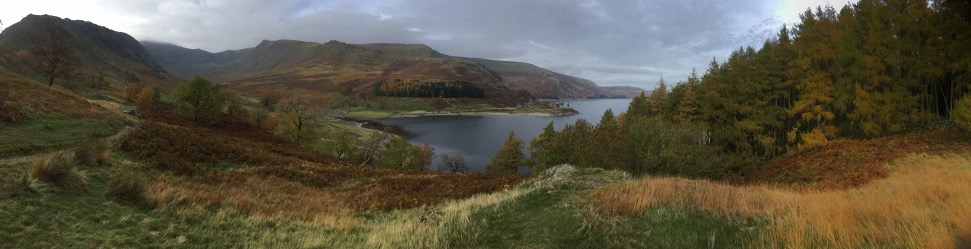 A body of water with hills and trees