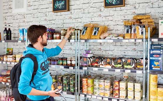 Student browsing brightly coloured food packaging in Root, Singleton Park Campus