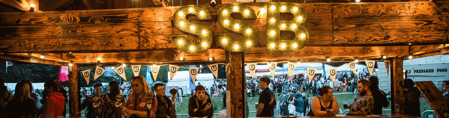 Summer Ball hut with students stood at Bar