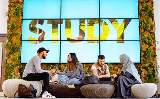 Four students conversing on campus. 