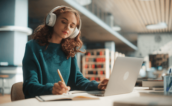 Student listening to masterclass on laptop.