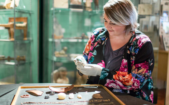 Woman examining ancient artifacts in the Egypt Centre