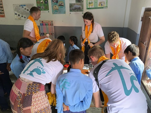 Group of volunteer students with school children